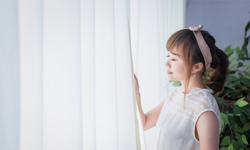 窓を開ける女性のイメージ画像
